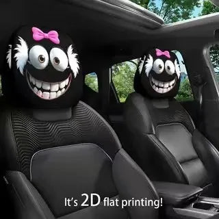A pair of black car headrest covers featuring creepy, smiling monster faces with pink bows.