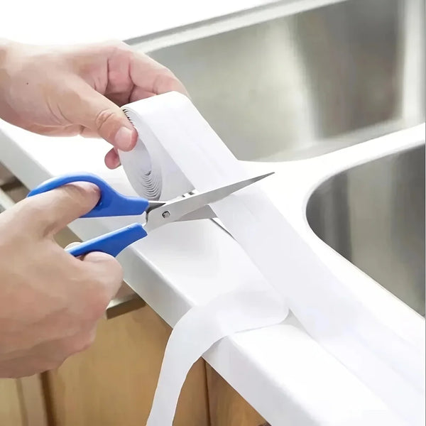 Manos usando tijeras para cortar una tira de cinta selladora impermeable blanca en un objeto de plástico blanco.