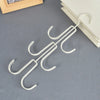 A white rotatable 3-layer hanging organizer for hats, bags, and scarves lying on a gray surface.