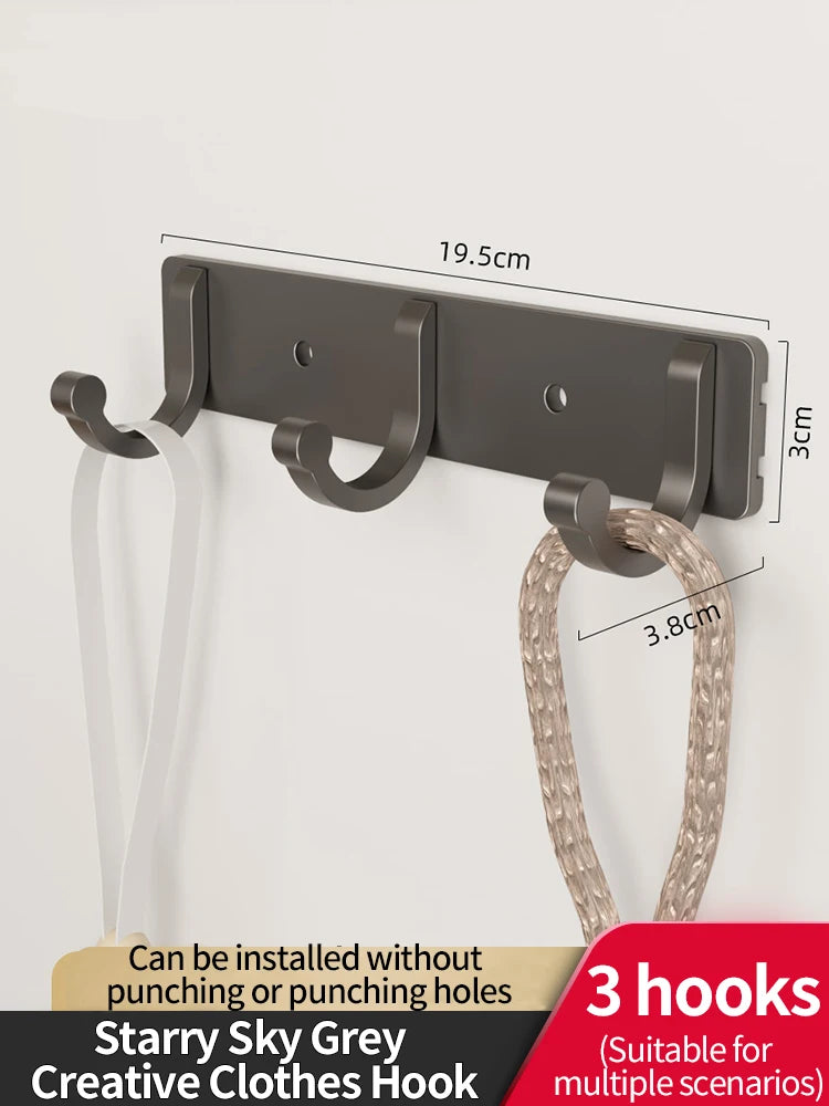 A set of three grey wall hooks with adhesive backing and a loop is shown against a white background.