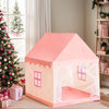 A pink play tent shaped like a castle with decorative trim and windows, set in a bright room.