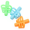 A set of three colorful ergonomic pencil grip trainers for posture correction, featuring green, light blue, and orange grips.
