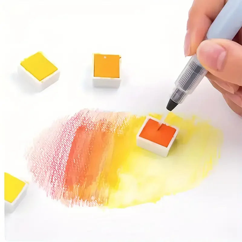A hand is dipping a fine tip watercolor brush pen into a colorful paint palette for artistic use.