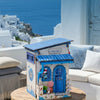 A wooden building miniature kit for a book nook featuring blue and white paint and LED lighting on a rustic table.