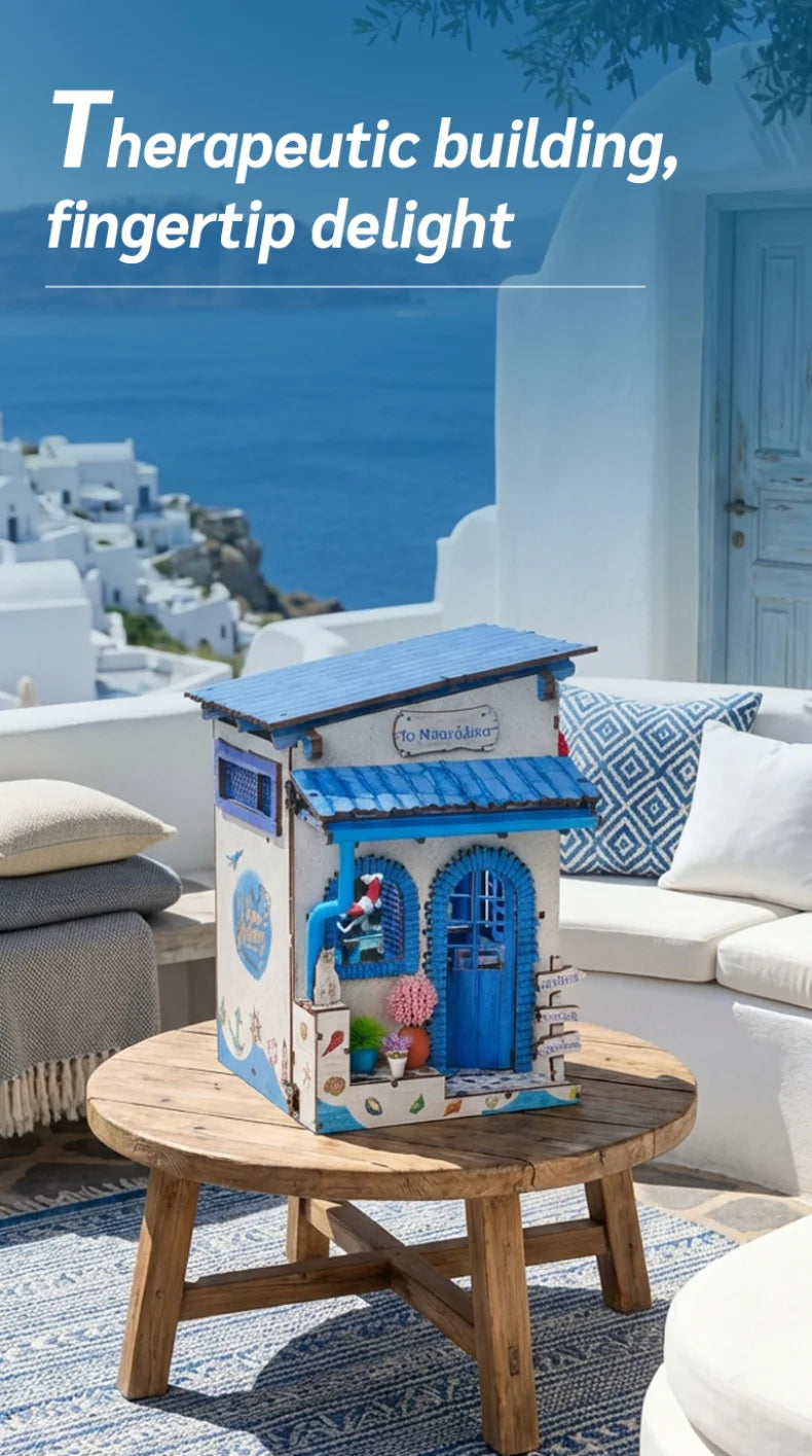 A wooden building miniature kit for a book nook featuring blue and white paint and LED lighting on a rustic table.