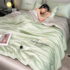 A light green ultra-soft comforter with embroidered 'always' text is displayed on a bed.
