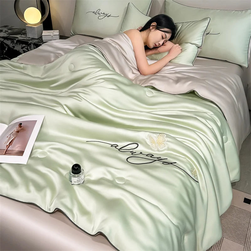 A light green ultra-soft comforter with embroidered 'always' text is displayed on a bed.