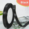 Black gold-edge satin ribbon rolled on and unrolled for crafts and gift wrapping