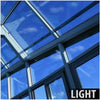 A close-up view of a modern glass roof structure with metal framing and blue sky visible through the panels.