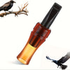 A glass whistle in an amber-brown color is shown next to a dark bird and a silhouette of a bird in flight.