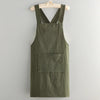 A dark olive green cotton kitchen apron hanging on a wooden hanger.