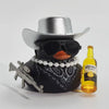 A black rubber duck ornament wearing a silver cowboy hat and sunglasses is displayed next to a bottle of Corona Extra.
