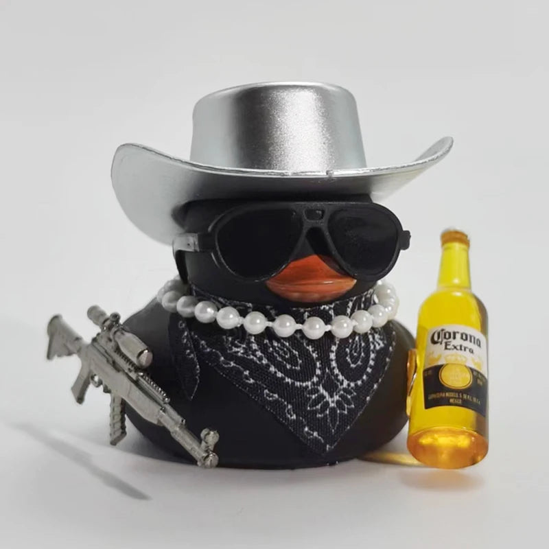 A black rubber duck ornament wearing a silver cowboy hat and sunglasses is displayed next to a bottle of Corona Extra.