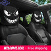 A pair of black car headrest covers featuring an evil grin design for car seats.