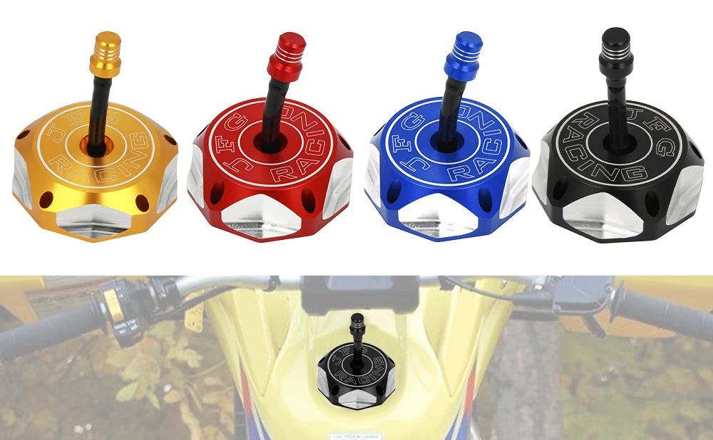 Four colored aluminum motorcycle fuel tank caps with different colored plugs displayed on a yellow motorcycle tank.