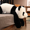 A large black and white panda plush toy lying on a gray surface.
