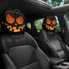 A pair of horror-themed car headrest covers featuring creepy jack-o'-lantern faces installed in a dark vehicle interior.