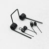 A collection of black double torsion springs with long wires and coiled ends.