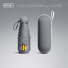 A dark grey mini six-frame umbrella is shown in two views, highlighting its compact design and UV50+ protection.