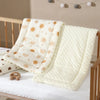 A white padded baby stroller seat cushion featuring a sun and rainbow pattern is displayed on a wooden crib.