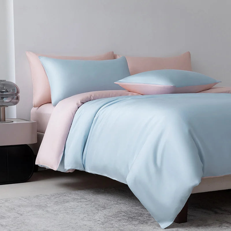 Luxuriöses hellblaues Bambus-Duvetcover-Set mit rosa Akzenten auf einem Bett.