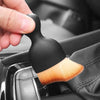 A hand holds a black ultra-soft curved detailing brush, used for cleaning car vents and gaps.