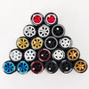 A collection of ten pairs of 1:64 scale alloy car wheels and tires in various colors including black, silver, gold, and blue.
