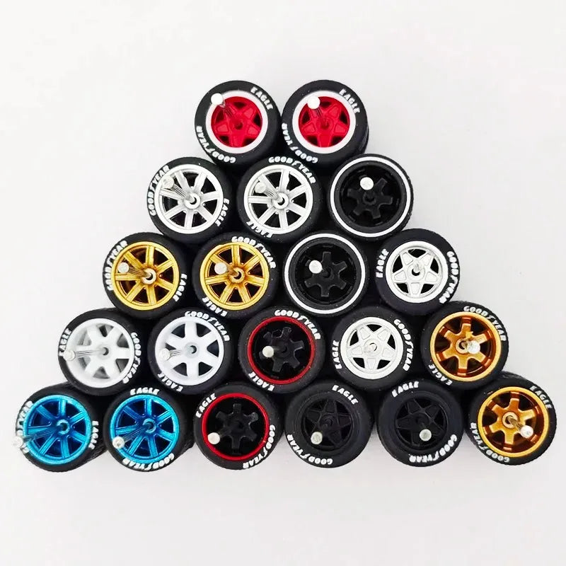 A collection of ten pairs of 1:64 scale alloy car wheels and tires in various colors including black, silver, gold, and blue.