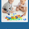 A toddler is interacting with colorful transparent letters and numbers scattered on a white surface for sensory learning.