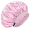 A pink silk sleep cap with gathered fabric and an adjustable band is shown from a side angle.