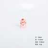 A small pink resin pig figurine with an orange snout and a blue camera accessory.