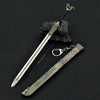 A detailed metal sword keychain featuring a blade and hilt, displayed next to a dark rock.