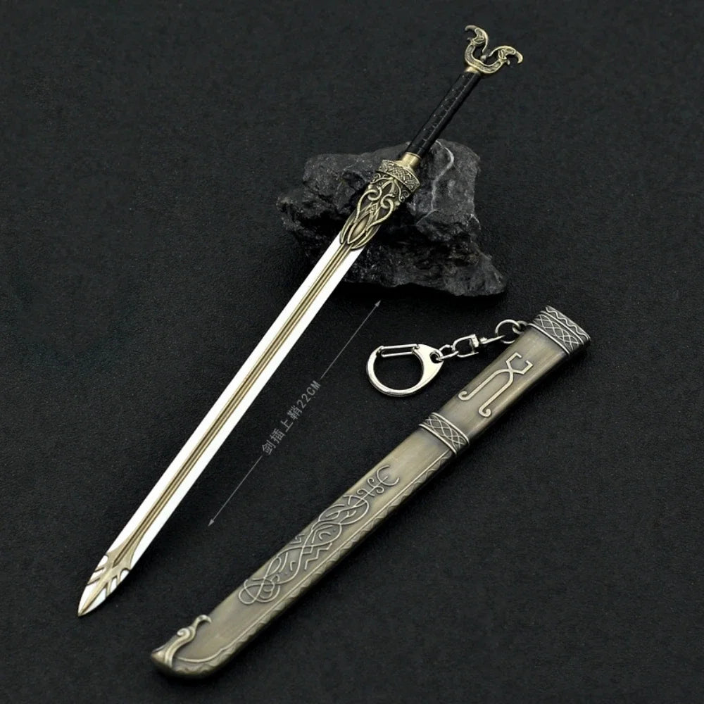 A detailed metal sword keychain featuring a blade and hilt, displayed next to a dark rock.
