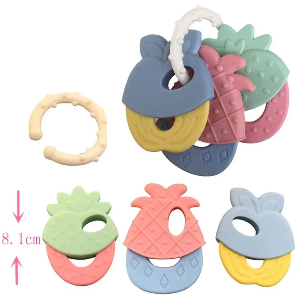A set of silicone fruit teethers and rattles in various colors including green, pink, yellow, and blue.