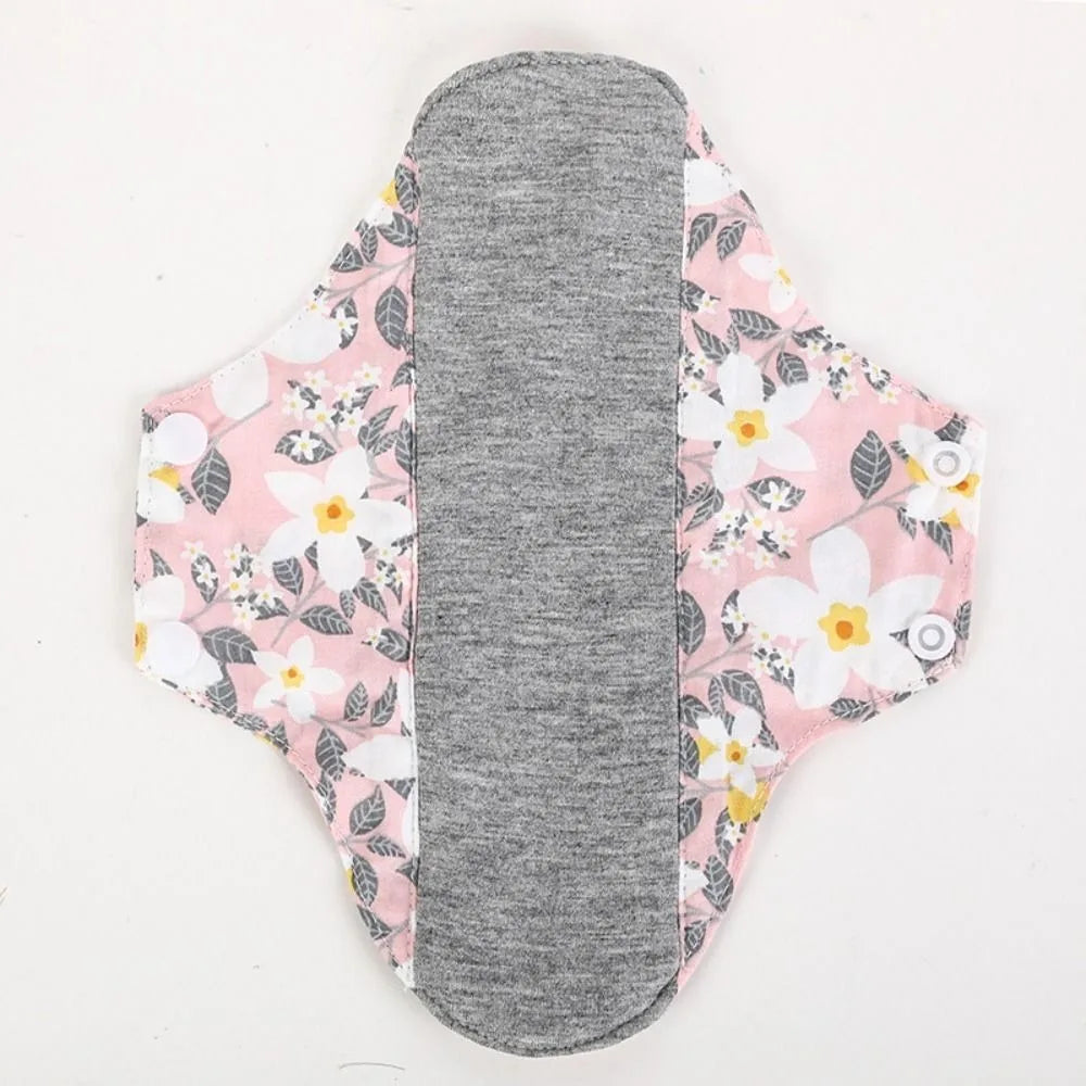 Reusable cotton menstrual pads in pink floral pattern with a gray absorbent core.