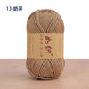 A ball of natural beige cotton blend crochet yarn is shown on a wooden surface.