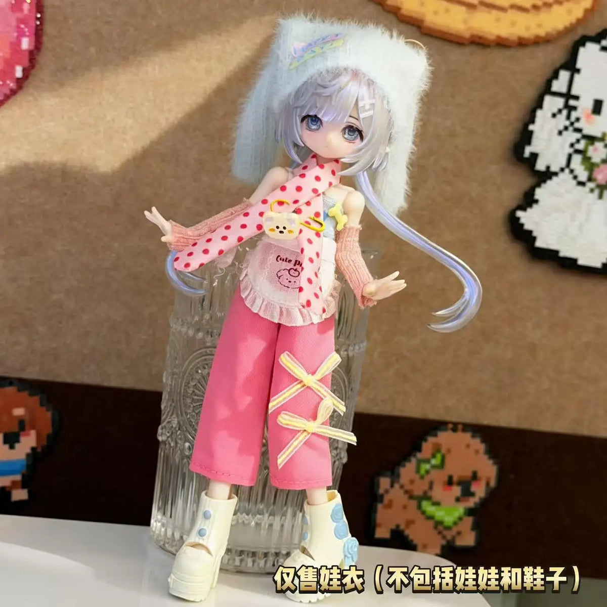 A female BJD doll wearing a pink dress outfit with white hair and pink pants.