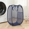 A dark blue mesh laundry hamper with a fabric base is shown next to a white washing machine.
