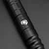 Close-up view of a black lightsaber hilt with a circular metallic light emitter.