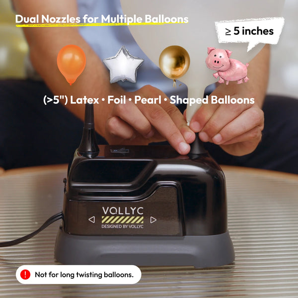 Une main utilise une pompe gonflante électrique Vollyc pour gonfler divers ballons en forme variée.
