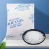 A white silica gel desiccant bag is shown next to a black dish filled with white silica gel beads.