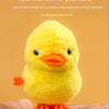 A yellow wind-up walking chicken toy is held in an open palm.