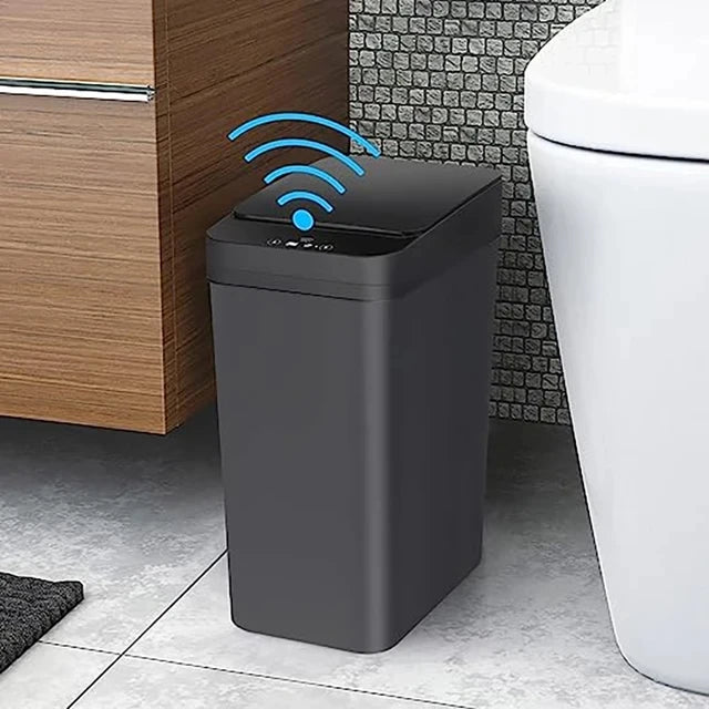 A modern, matte gray touchless trash can with a motion sensor is placed next to a toilet.