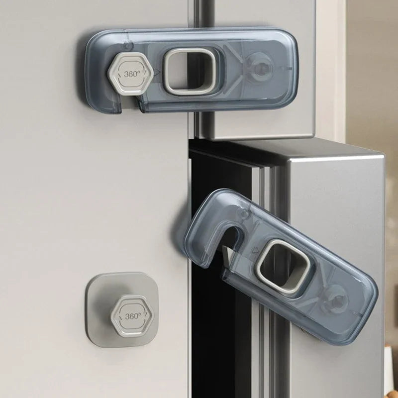 Close-up of a clear plastic child safety cabinet lock mechanism on a refrigerator door.