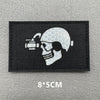 A black embroidered patch featuring a white skull with a scope and a crosshair design.