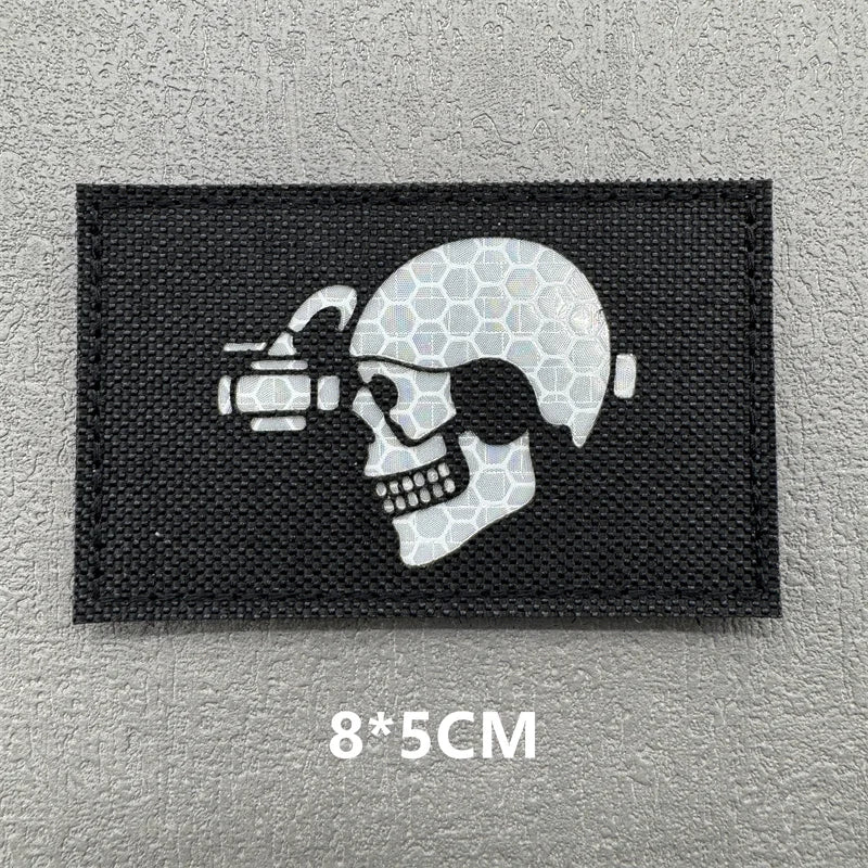 A black embroidered patch featuring a white skull with a scope and a crosshair design.