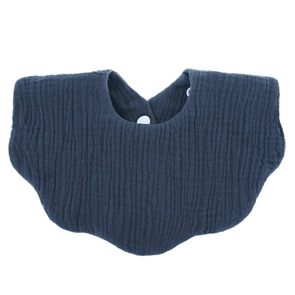 A navy blue knitted baby bib in a bandana style with a cutout for the neck.