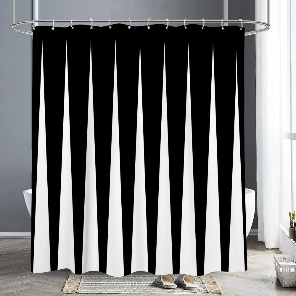 Black and white abstract geometric shower curtain hanging on a rod in a bathroom setting