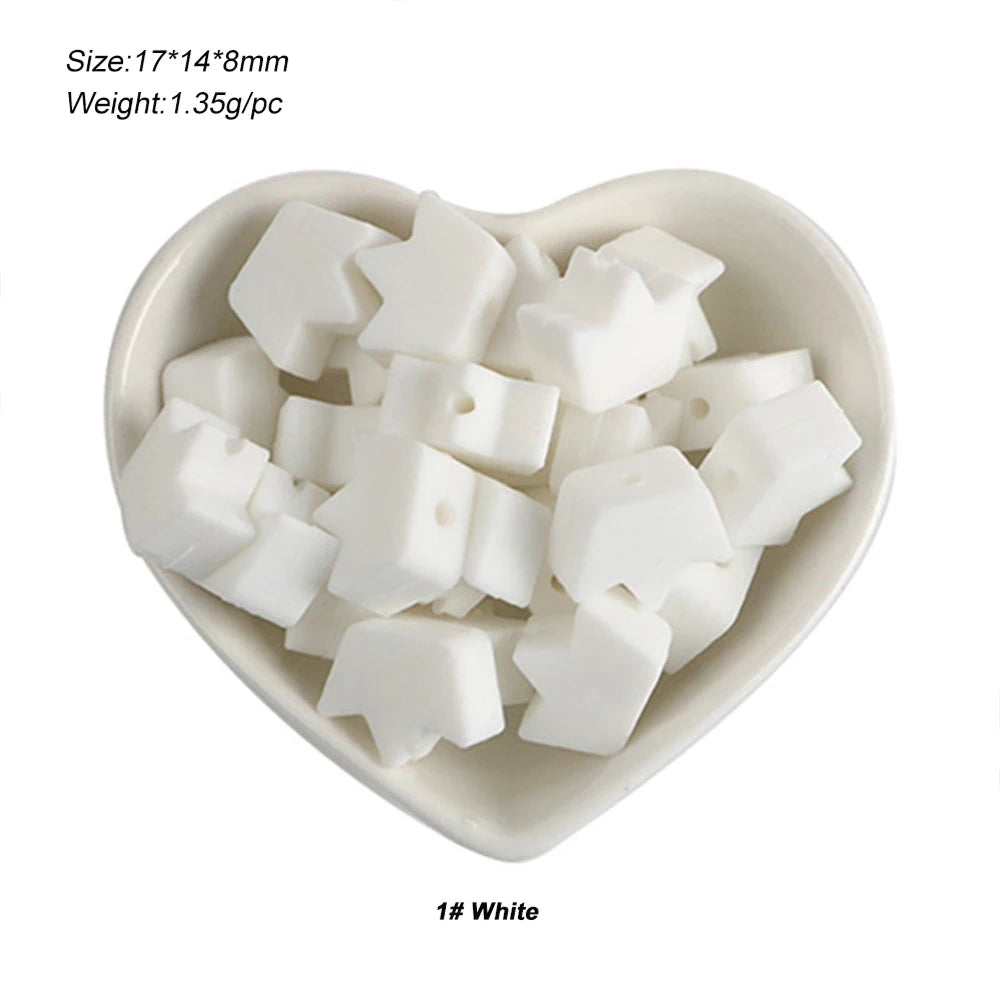 A small white bowl filled with silicone crown star heart beads for DIY jewelry making