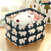 A white rabbit figurine is placed inside a dark fabric storage basket with handles.